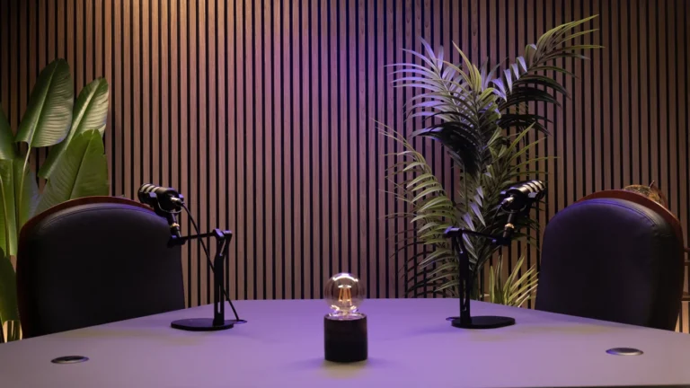 Allestimento con luce viola, due poltrone e due microfoni nello studio Podbox